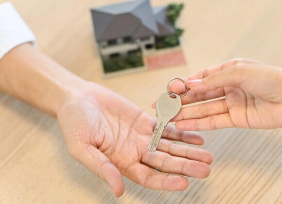 Hand of a woman handing over the house key