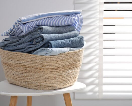 Laundry basket with clothes on table indoors