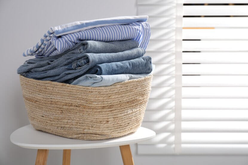Wäschekörbe & Co.: So gelingt die perfekte Wäscheorganisation Laundry basket with clothes on table indoors